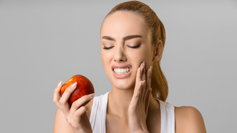 Une femme qui a mal aux dents quand elle mange