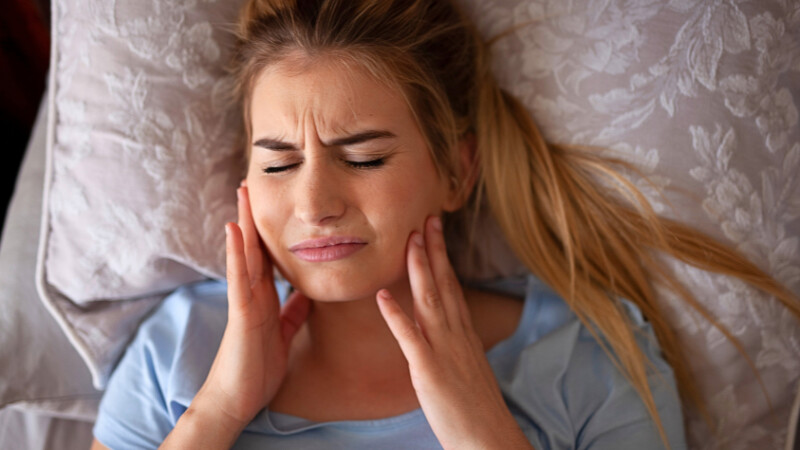 Une femme qui souffre d'anxiété et qui a le bruxisme pendant son sommeil