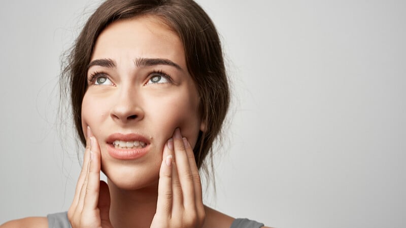 Une femme souffrant de mal de dent à cause de problèmes émotionnels