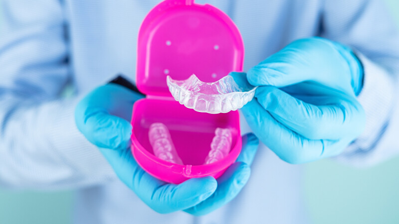 Un dentiste posant avec des gouttières de blanchiment