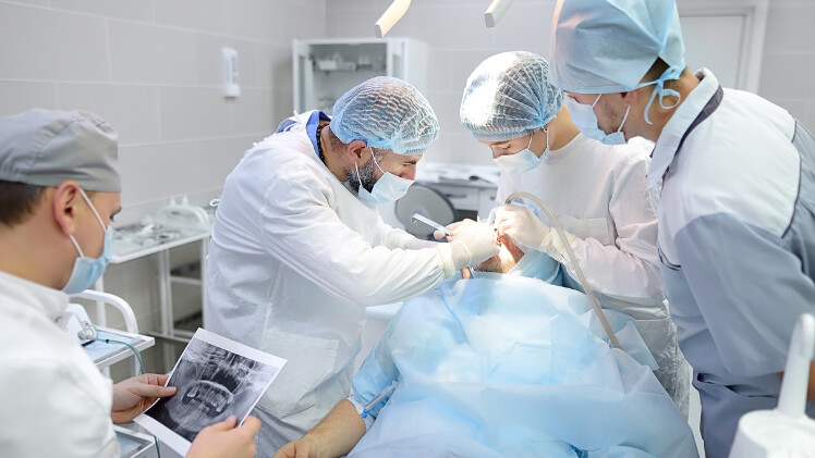 Un spécialiste en implant dentaire réalisant une chirurgie d'implantation