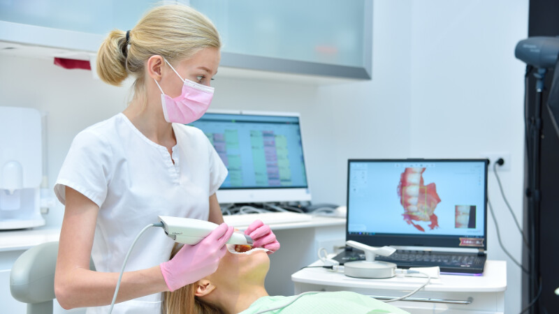 Une dentiste prenant les empreintes dentaires d'une cliente pour la conception de facettes