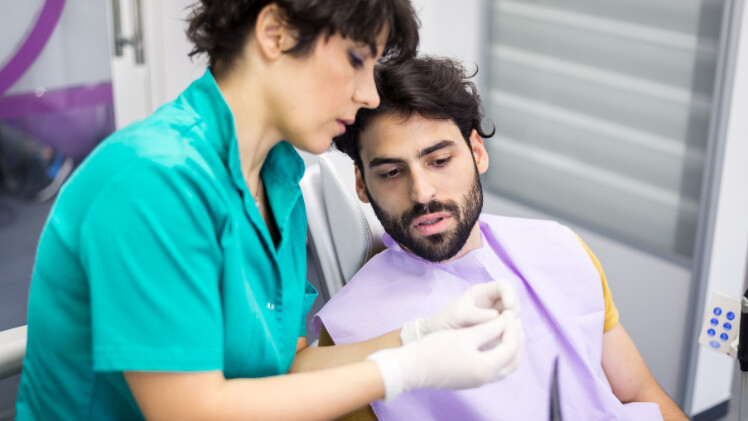 Une dentiste qui explique à un patient l'inlay