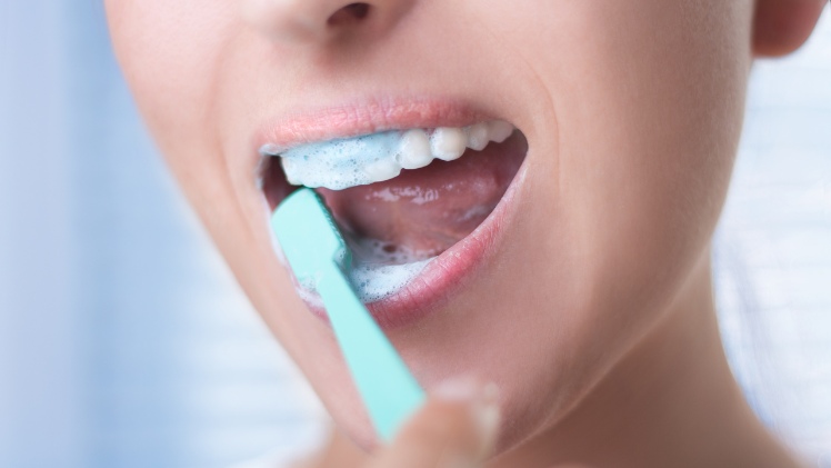 Une femme qui entretient ses dents par un bon brossage