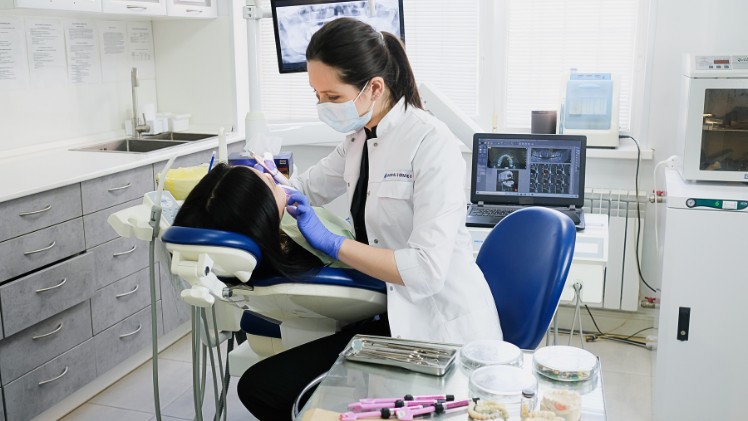 Une femme qui se fait contrôler l'alignement de ses dents chez une dentiste