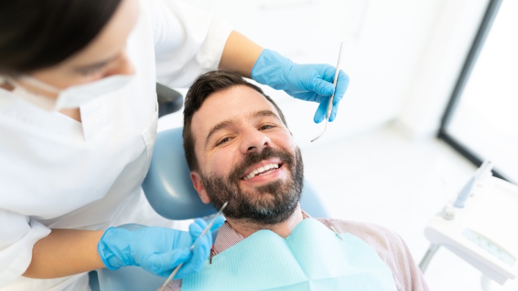 Un homme qui se fait contrôler ses dents et sa santé dentaire