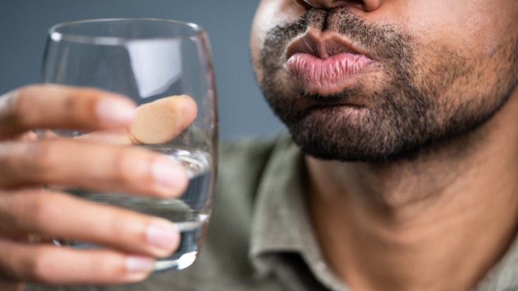 Un homme qui se rince la bouche après avoir mangé pour protéger son émail de l'érosion