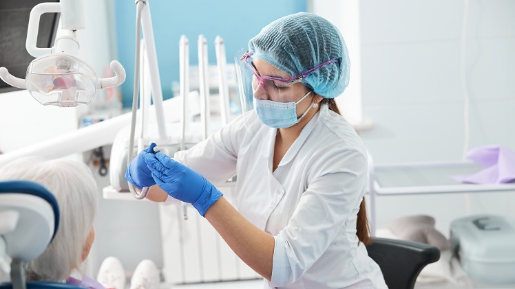 Une dentiste qui installe une fraise dentaire diamantée