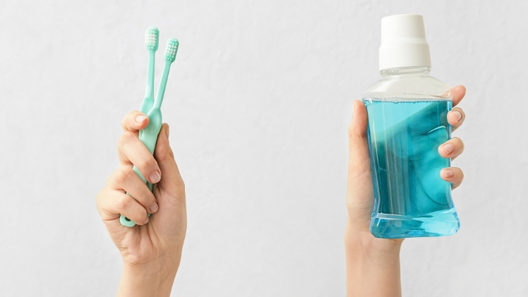 Une personne qui va utiliser une solution de bain de bouche au fluor pour prévenir l'érosion de ses dents