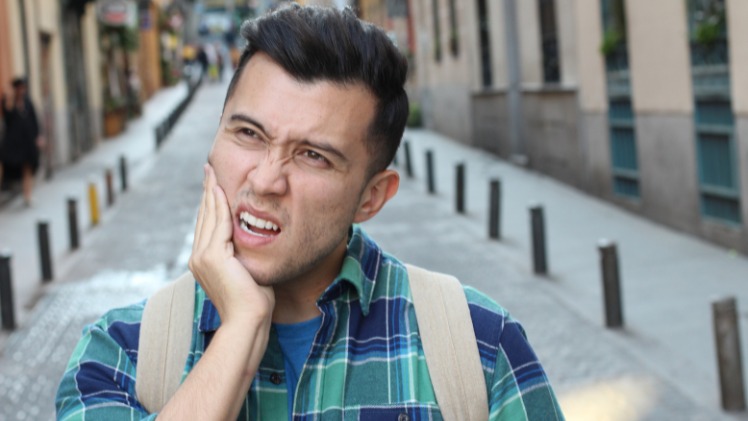 Un homme qui a mal aux dents à cause de ses serrements dentaires