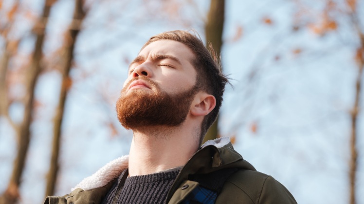 Un homme qui fait de la relaxation et des exercices de respiration pour mieux sourire