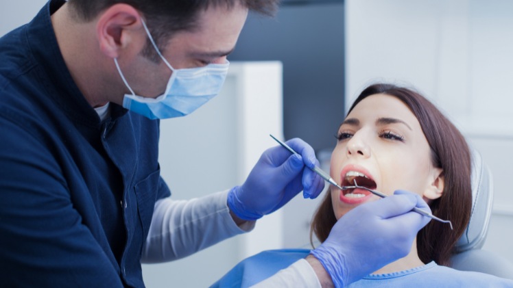 Un dentiste spécialiste de la réflexologie des dents avec une patiente
