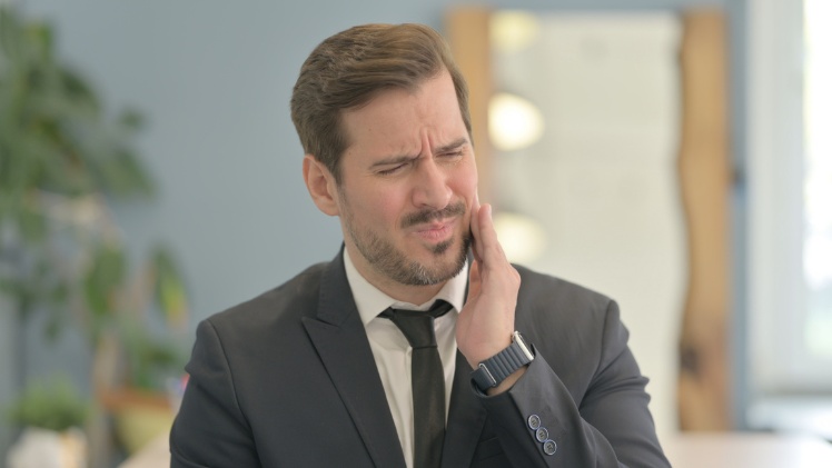 Un homme avec un mal dentaire à cause du stress