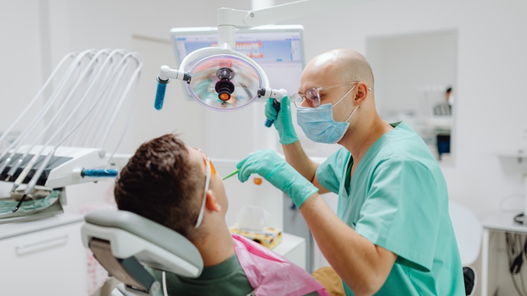Un homme en rendez-vous chez le dentiste pour le remplacement de sa contention dentaire