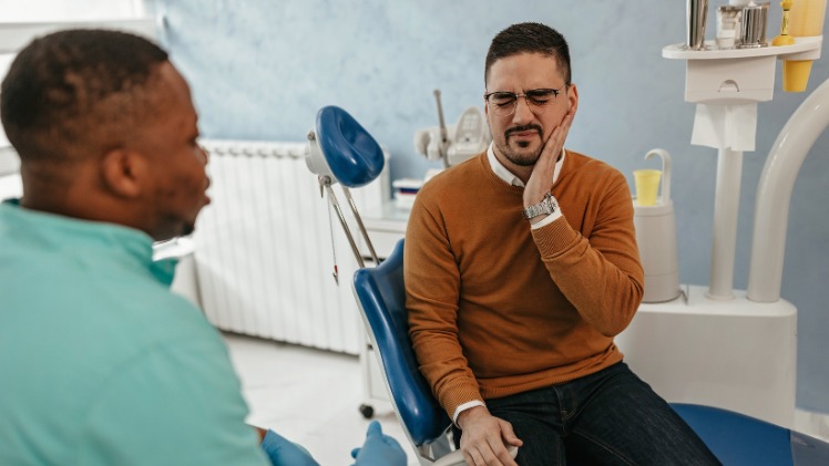 Un praticien spécialiste en réflexologie dentaire avec un patient