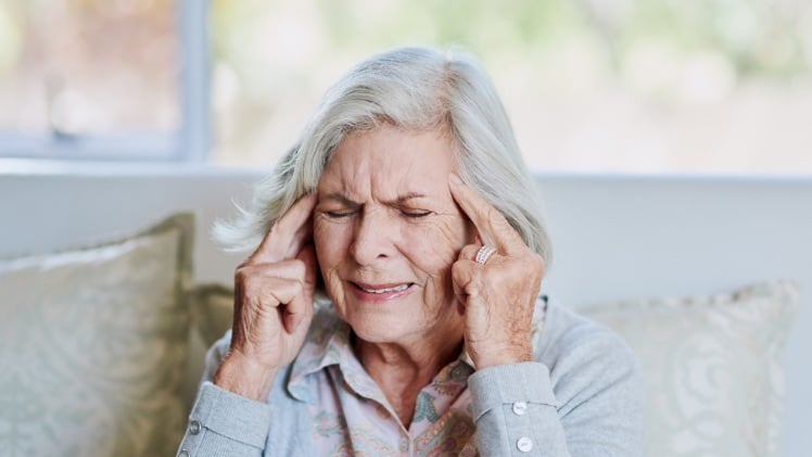 Une femme âgée qui a une inflammation des gencives due à une prothèse dentaire