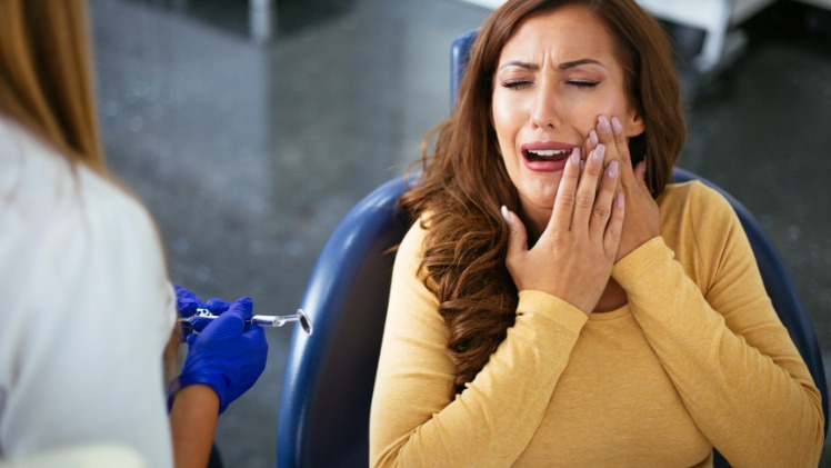 Une femme ayant les symptômes d'une mauvaise hygiène dentaire