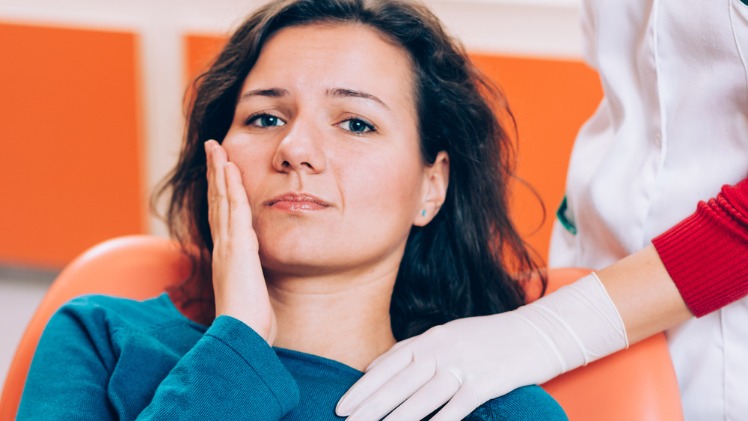 Une femme qui a un problème de déplacement des dents douloureux