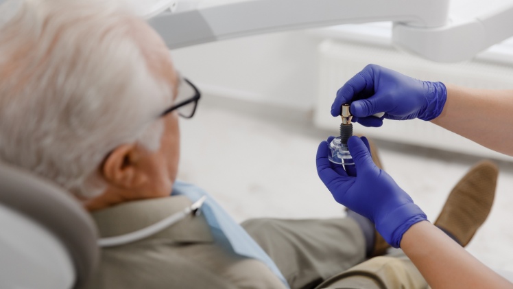 Un dentiste qui explique le fonctionnement d'un implant à un patient
