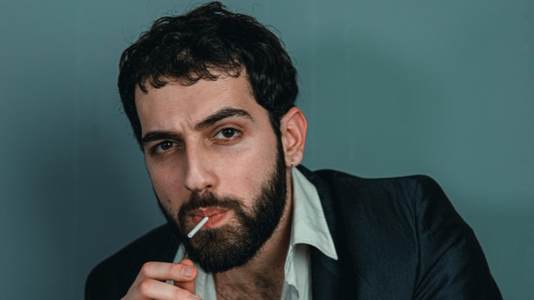 Un homme avec des dents mal alignées qui suce une sucette