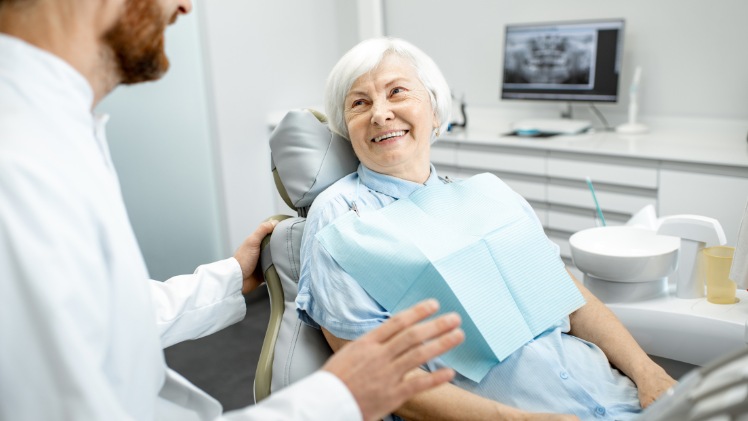 Une femme âgée qui consulte un dentiste pour vérifier la cicatrisation de son all-on-6