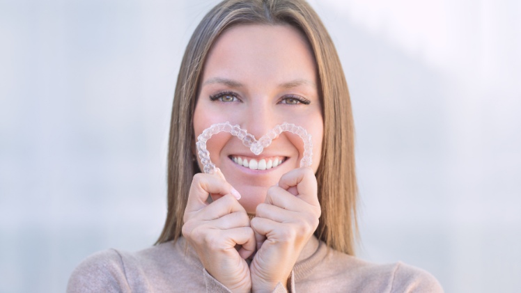 Une femme avec des dents bien alignées grâce à des facettes dentaires