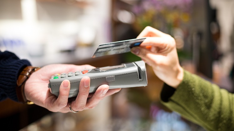 Une personne qui paie les frais de son all-on-six par carte bancaire